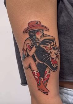 a person with a tattoo on their arm and a cat wearing a cowboy's hat