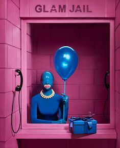 a blue mannequin in a pink room with a balloon