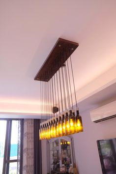 a chandelier made out of glass bottles hanging from the ceiling in a living room