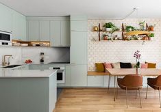 an open kitchen and dining room with white walls, wood floors and wooden flooring