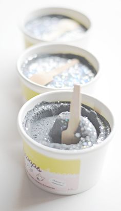 three ice cream cups with spoons in them