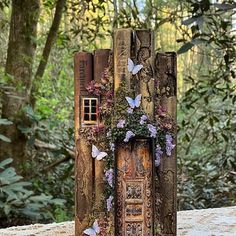 a book sculpture with flowers and butterflies on it's cover in front of some trees