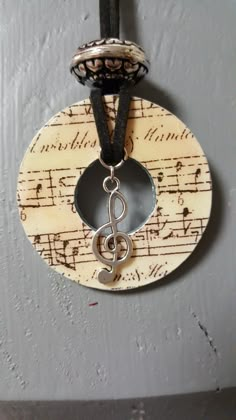 a musical note is hanging from a string on a circle with music notes in it