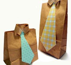 two paper bags with ties on them sitting next to each other in front of a white background