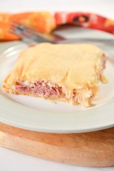 a piece of food on a plate with a knife and fork next to the plate