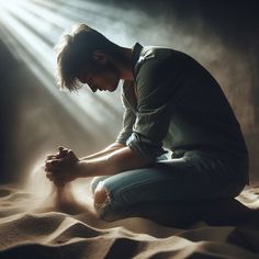 a man kneeling down in the sand with his hands on his knees and light streaming through him