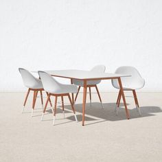 a table and four chairs sitting in front of a white wall