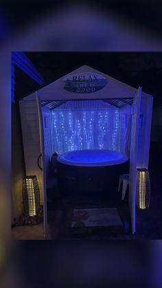 a hot tub in the middle of a room with blue lights on it's sides