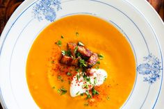 a white bowl filled with soup on top of a wooden table