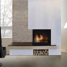 a living room with a fire place in the center and a chair next to it