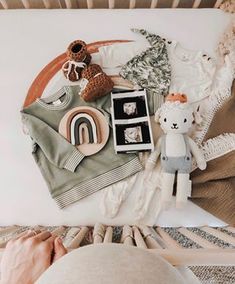 a baby's crib with toys and other items on the floor, including a teddy bear