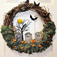 a wreath decorated with fake moss and halloween decorations