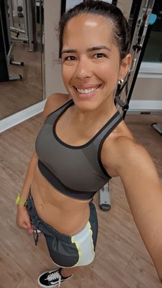 a woman is smiling in the gym