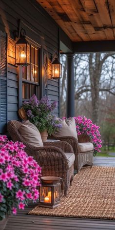 a porch with wicker furniture and flowers on the front steps, lit by lanterns