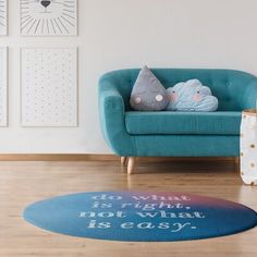 a living room with a blue couch and two pictures on the wall above it,