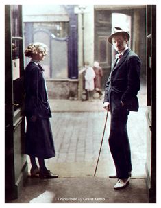 an old photo of two people standing in front of a door with canes and hats on