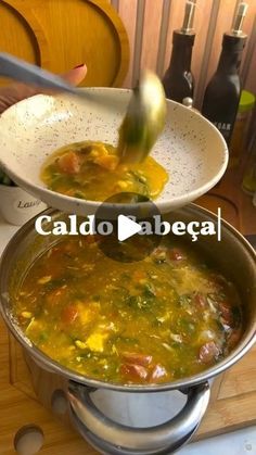 a ladle full of soup is being lifted from a pot with the lid down