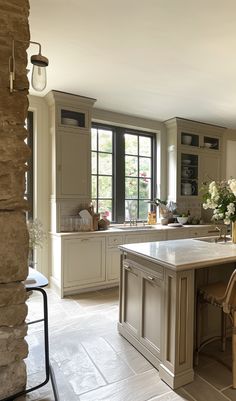 a large kitchen with an island in the middle and two chairs at the counter top