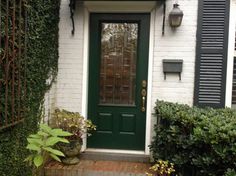 a green front door on a white brick house