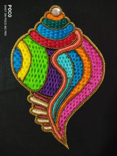 a colorful fish is embroidered onto a black background