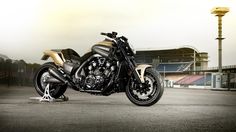 a black and gold motorcycle parked in front of a stadium