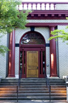 an entrance to a building with steps leading up to it and a wooden door on the front