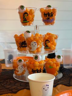 halloween treats are arranged in plastic cups on a table