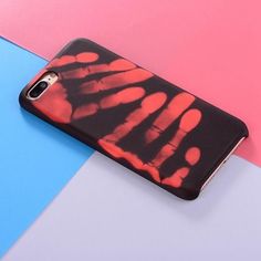 a cell phone case with red and black designs on the back, against a multi - colored background