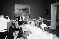 a group of people sitting around a table with candles in front of them and one person taking a photo