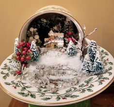 a christmas scene on a plate with trees and houses in the center, surrounded by snow