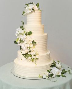 a wedding cake with white flowers and greenery