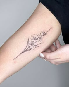 a woman's arm with a flower tattoo on it