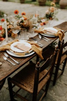 the table is set with plates and place settings