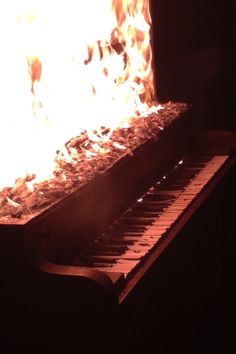 the piano is glowing brightly in the dark with fire coming from it's sides