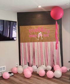 balloons and streamers are on the floor in front of a wall with a sign