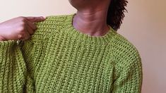 a woman in a green sweater is holding her hand on the shoulder