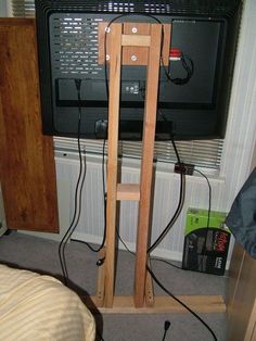 a television is sitting on a stand in front of a window with wires attached to it