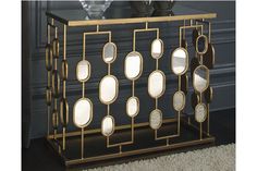 a black and gold sideboard with mirrors on it next to a vase filled with flowers