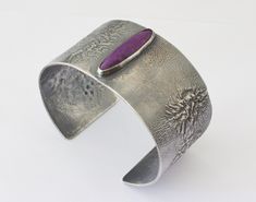 A very nice handmade cuff formed from 18 gauge Reticulation Silver.  The cuff is highlighted with a really nice Sugilite Gemstone.  The surface of the cuff has been oxidized and the oxidation partially removed to bring out the organic, dendritic nature of the surface. The cuff has an internal circumference of 7 inches which includes the gap of 1 inch. The bracelet is 1.3 inch wide. This would be a standard size bracelet that can be adjusted a bit. The Sugilite gemstone is natural and untreated. Mens Silver Cuff Bracelet, Gold Moonstone Ring, Womens Cuff Bracelets, Cuff Bracelets Handmade, Mens Cuff, Wide Cuff Bracelets, Natural Stone Bracelets, Unisex Bracelets, Silver Pieces