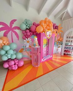 there are balloons and decorations on the floor in front of a wall that is decorated with palm trees