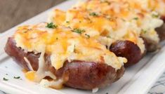 two hot dogs covered in cheese on a plate