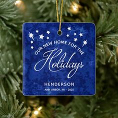 a blue ornament hanging from a christmas tree that says our new home for the holidays