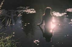 a woman sitting in the water at night