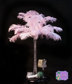 a small palm tree with pink feathers on it's trunk and some other items