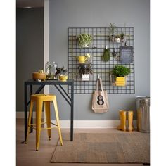 a room with yellow stools and plants on the wall