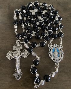 "This beautiful handmade rosary is made with 8mm black glass pearls,silver plated beads, 2\" Pardon crucifix. Length: 20\" inches long" Adjustable Black Rosary With Cross, Adjustable Black Cross Rosary, Adjustable Silver Rosary With Black Beads, Silver Rosary With Black Beads And Crucifix, Silver Rosary With Black Beads As Gift, Black Cross Rosary As Gift, Black Beaded Cross Rosary, Black Beaded Cross-shaped Rosary, Adjustable Black Rosary With 8mm Beads