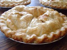 three pies sitting on top of a wooden table