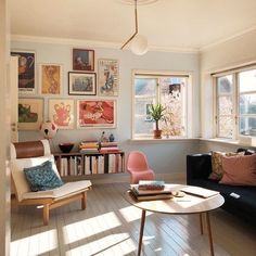 a living room filled with furniture and lots of pictures hanging on the wall above it