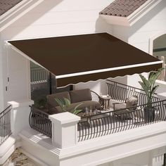 an overhead view of a patio with chairs and tables under a brown awning on the balcony