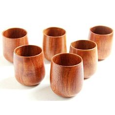 six wooden cups are lined up in a row